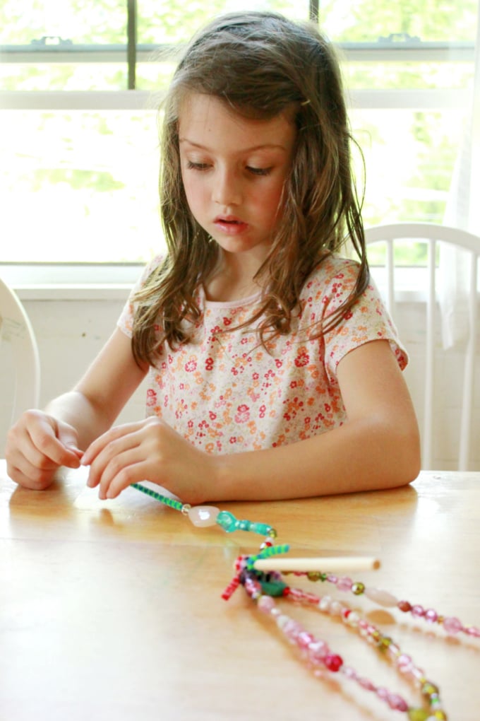 child making beaded garden ornament