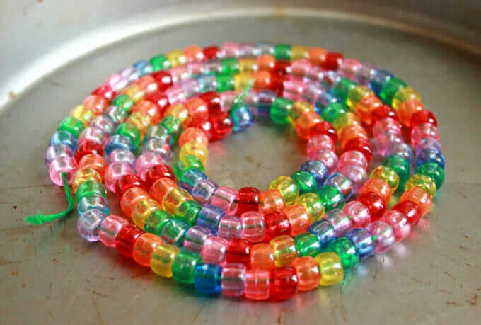 a spiral of pony beads arranged on metal pan for making melted bead art