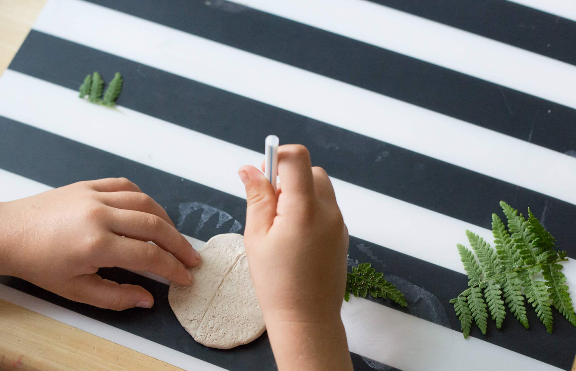 Add a hole at the top of your clay leaf print with a straw