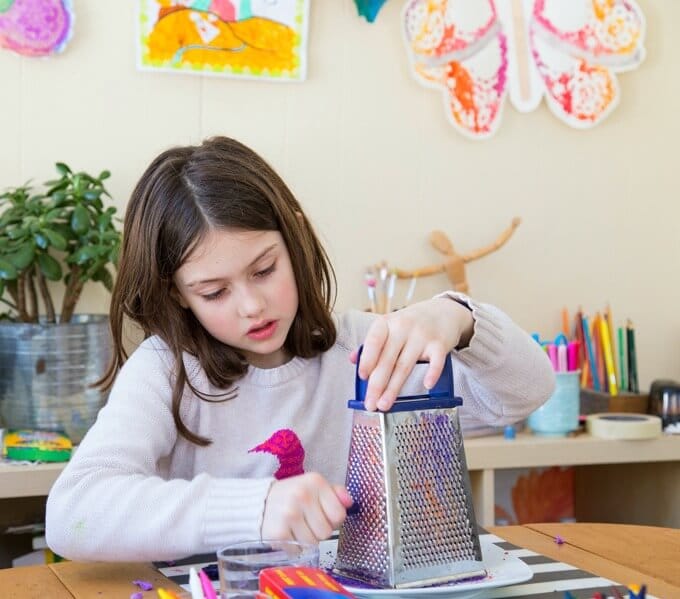 Grating crayons on the cheese grater