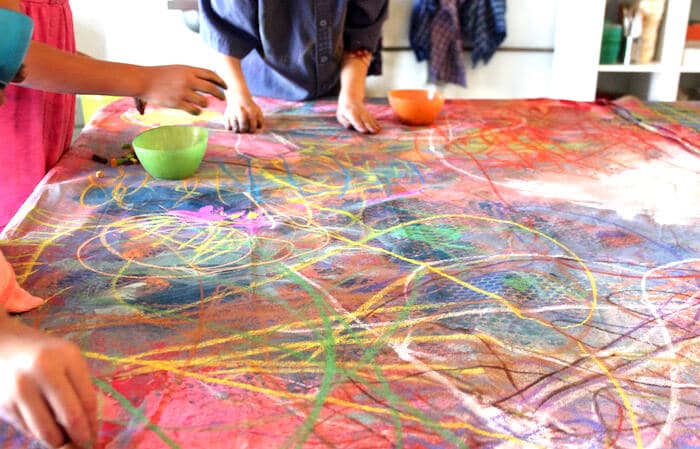 Drawing with chalk pastels for a collaborative mural art project.