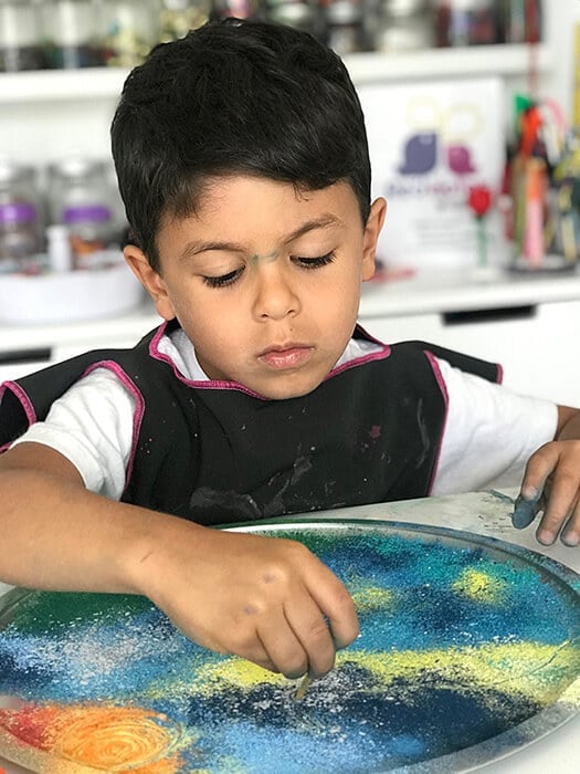 Swirling a design with chalk dust – an easy chalk art activity.