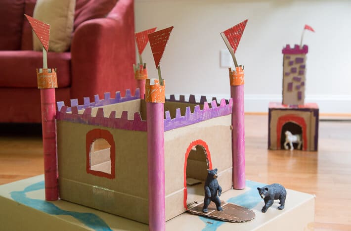 Playing with cardboard castles and animal figurines