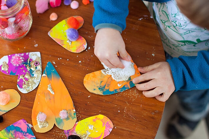 Boy gluing cardboard heart valentine