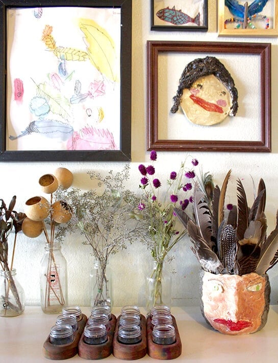 Easy nature drawing ideas for kids – artwork hanging in frames on the wall along with flowers & feather for observational drawing