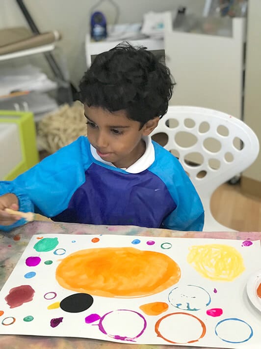 Boy painting Yayoi Kusama Inspired Dot Paintings for Kids
