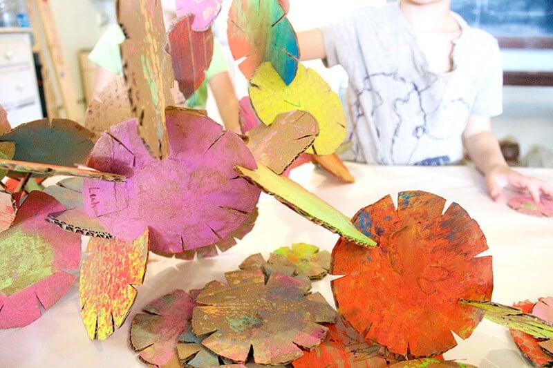 Child with cardboard building disc sculptures