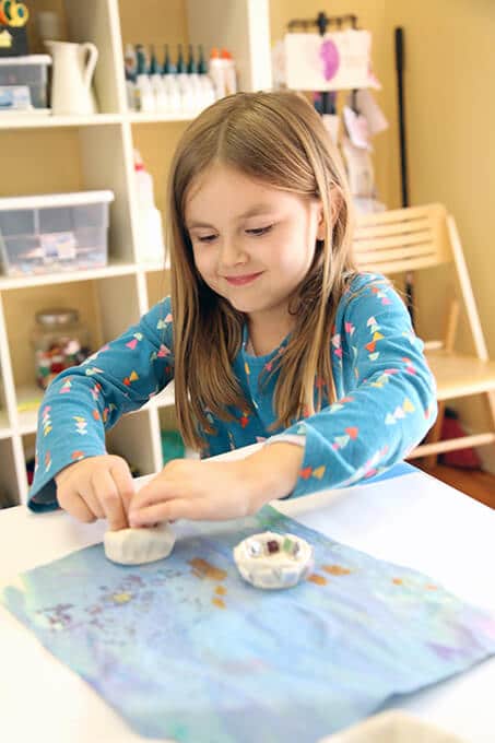 Child making a mosaic tile clay bowl with air dry clay