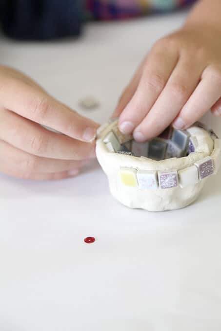 Child making an air dry clay bowl for mosaic art