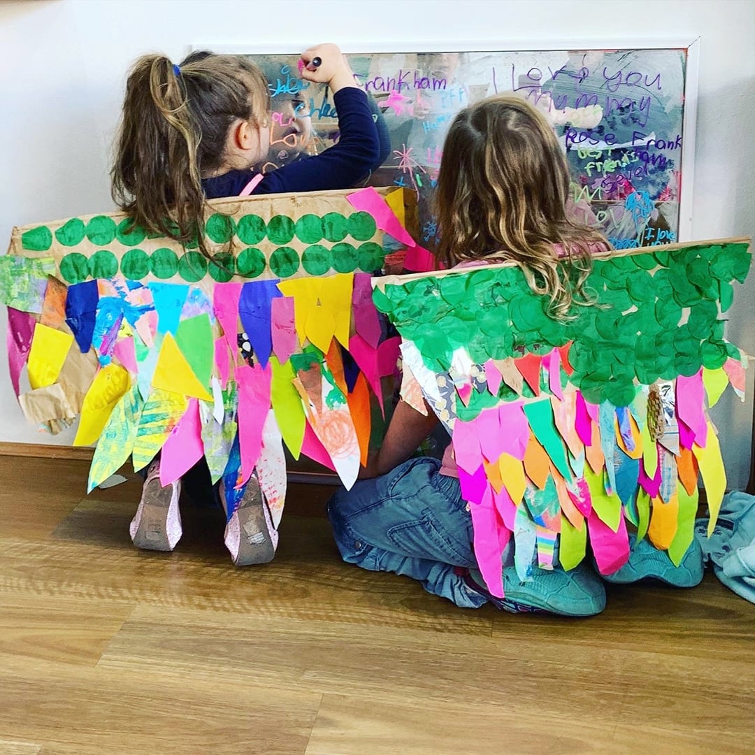 Two girls with wearing brightly colored DIY paper wings