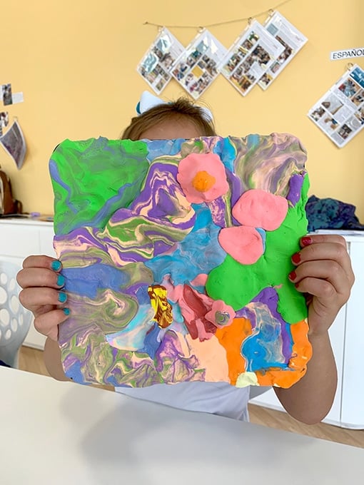 Child holding up clay project