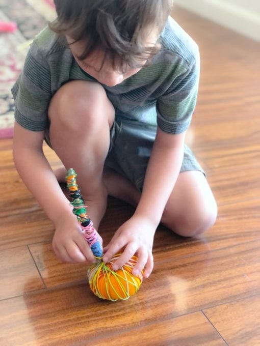child wrapping wire around pumpkin