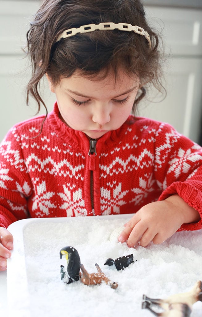 Child with winter sensory play bin instant snow