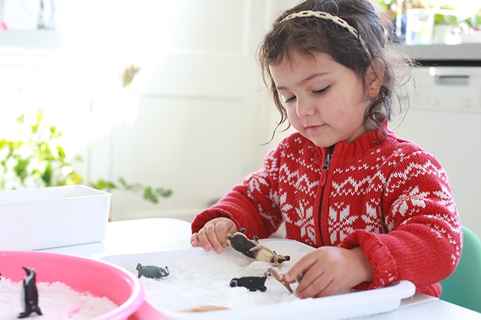 child with arctic animal toys and winter sensory play tray