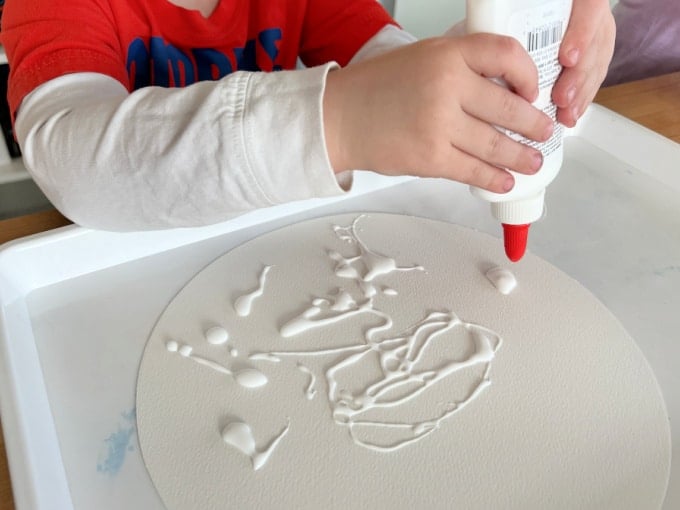 squeezing glue onto paper