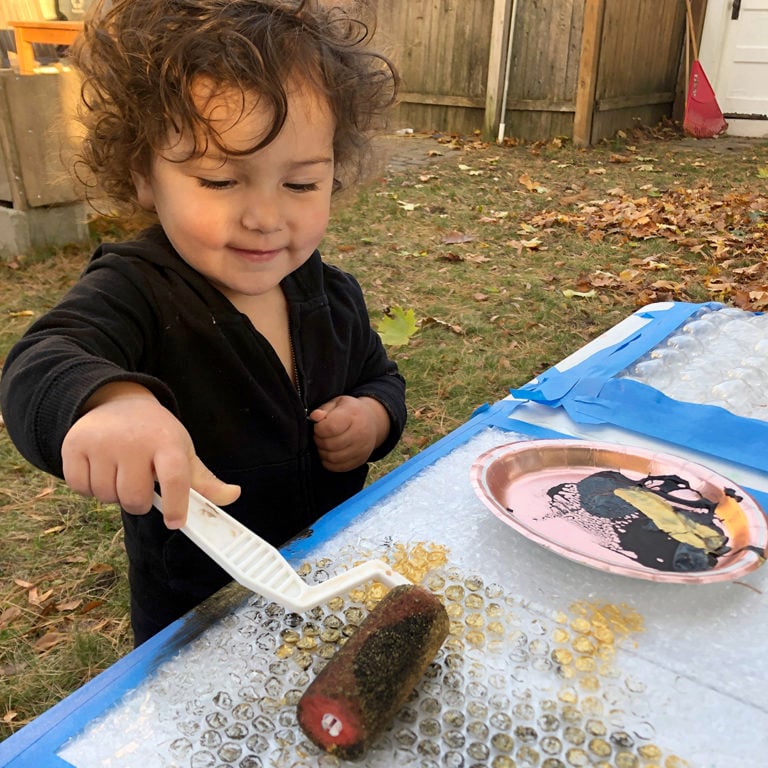Child rolling paint onto bubble wrap 2