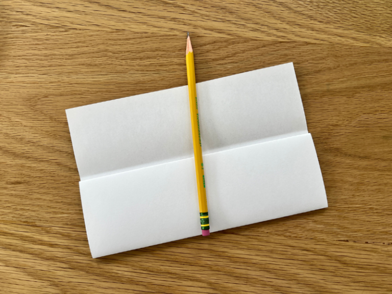 folded paper and pencil