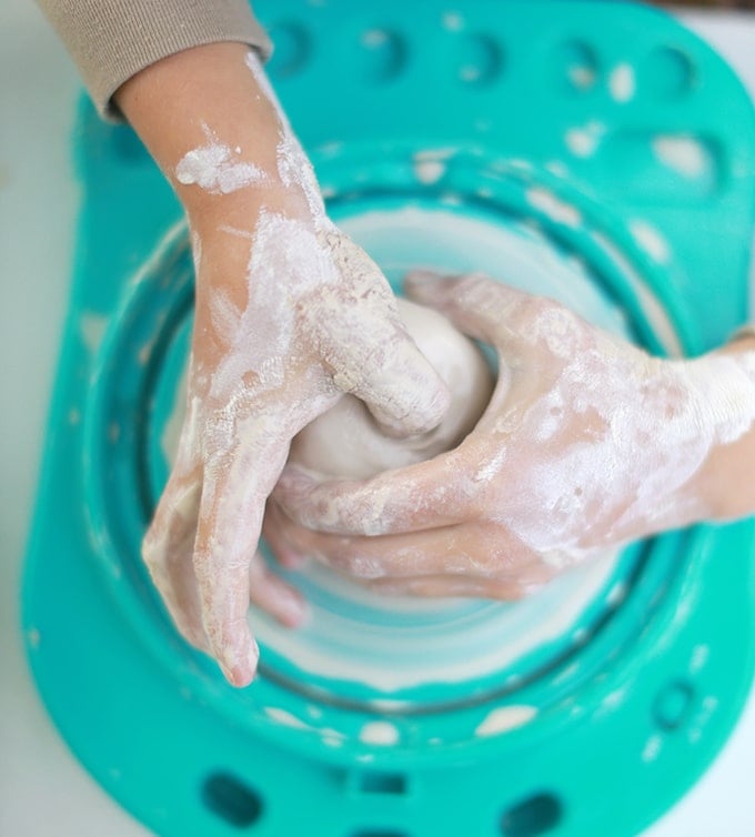 Child opening up clay pot