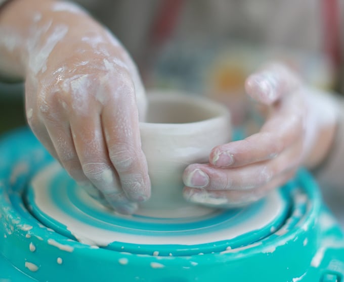 child raising clay pot