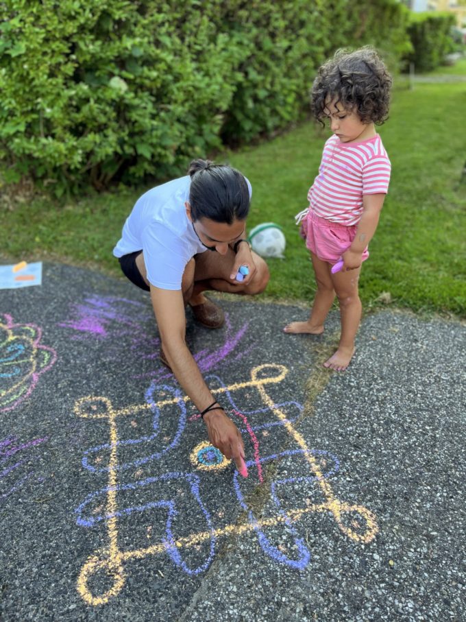 child and parent drawing chalk designs