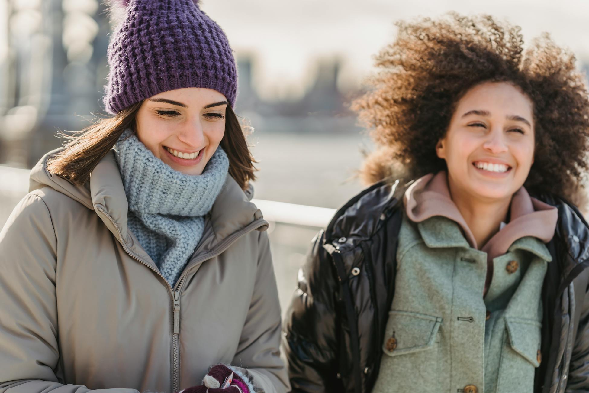 Adult daughter and mother walking together on a city promenade on a sunny cold day