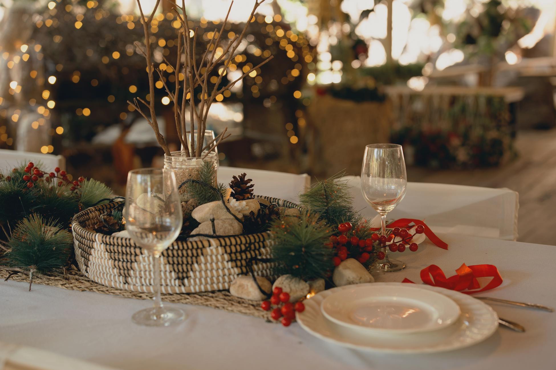 Elegant holiday table setting with festive decorations and warm lighting indoors.