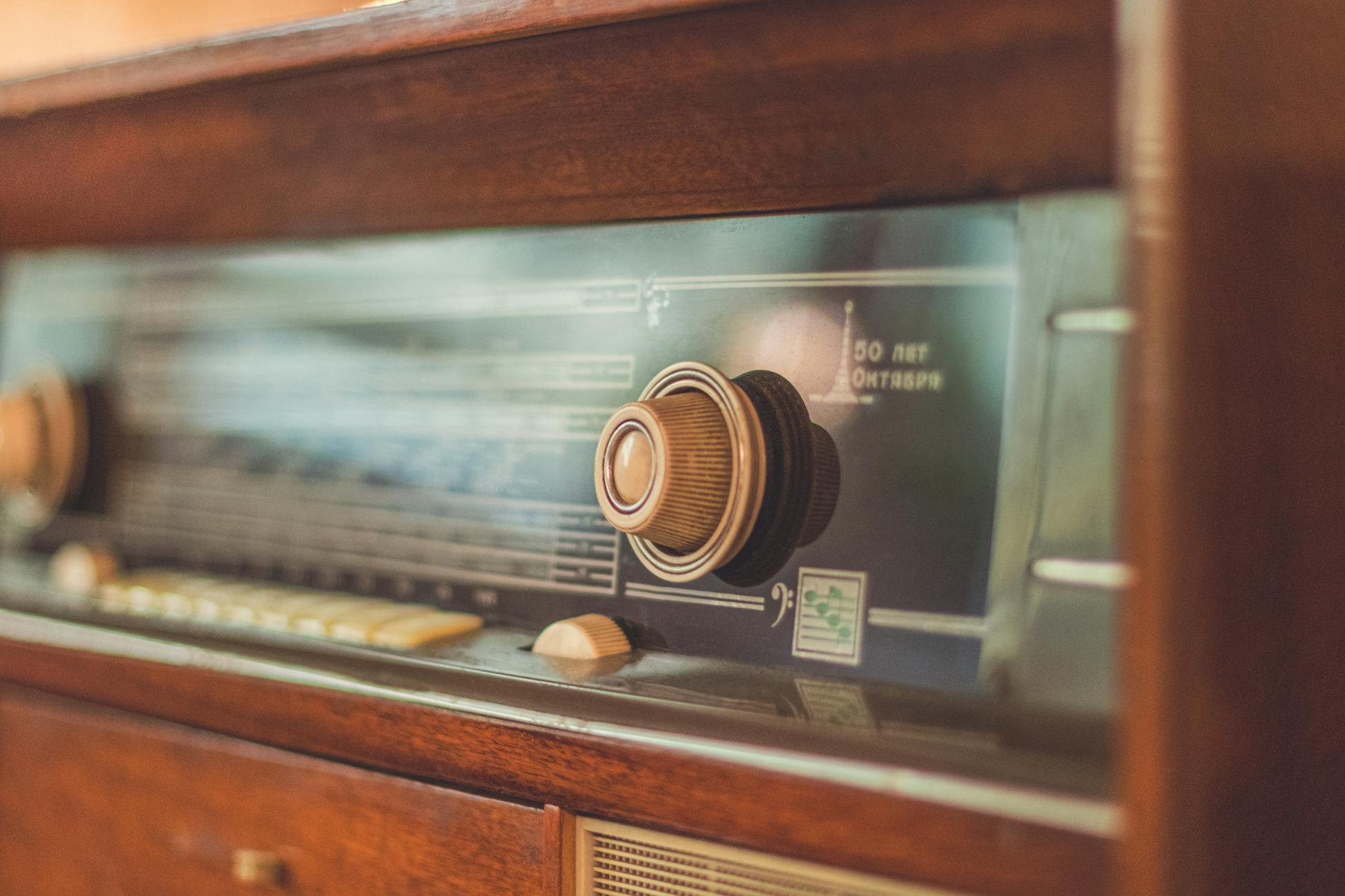 Close-up of a vintage radio showcasing its knobs and dial, reflecting retro style.