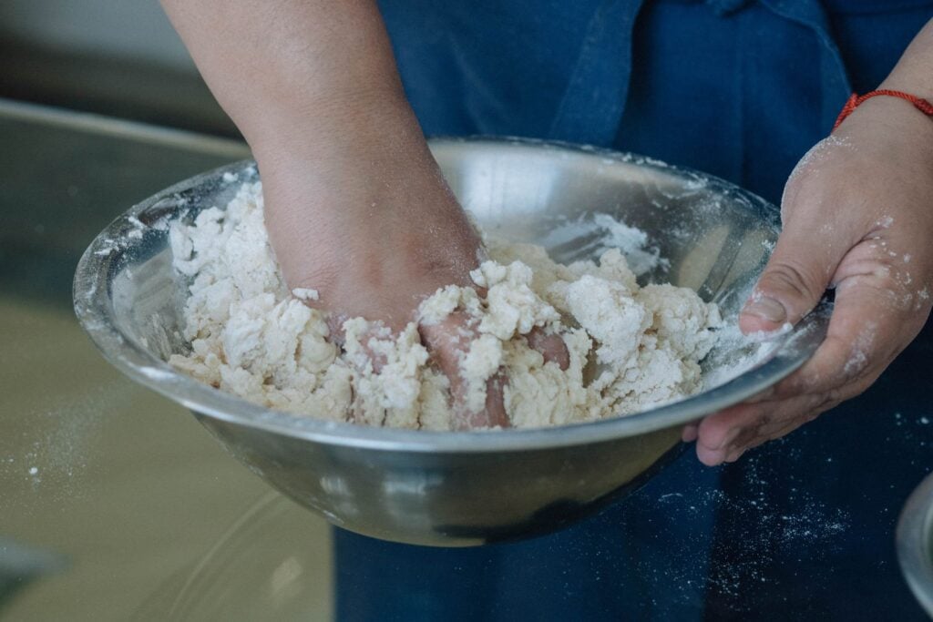 When a child squeezes a fistful of cornstarch-and-water slurry, the long starch chains jam together and behave like a solid, but the moment the hand relaxes the same mixture drips through their fingers like cream — a shear-thickening fluid that only exists while it is being touched.