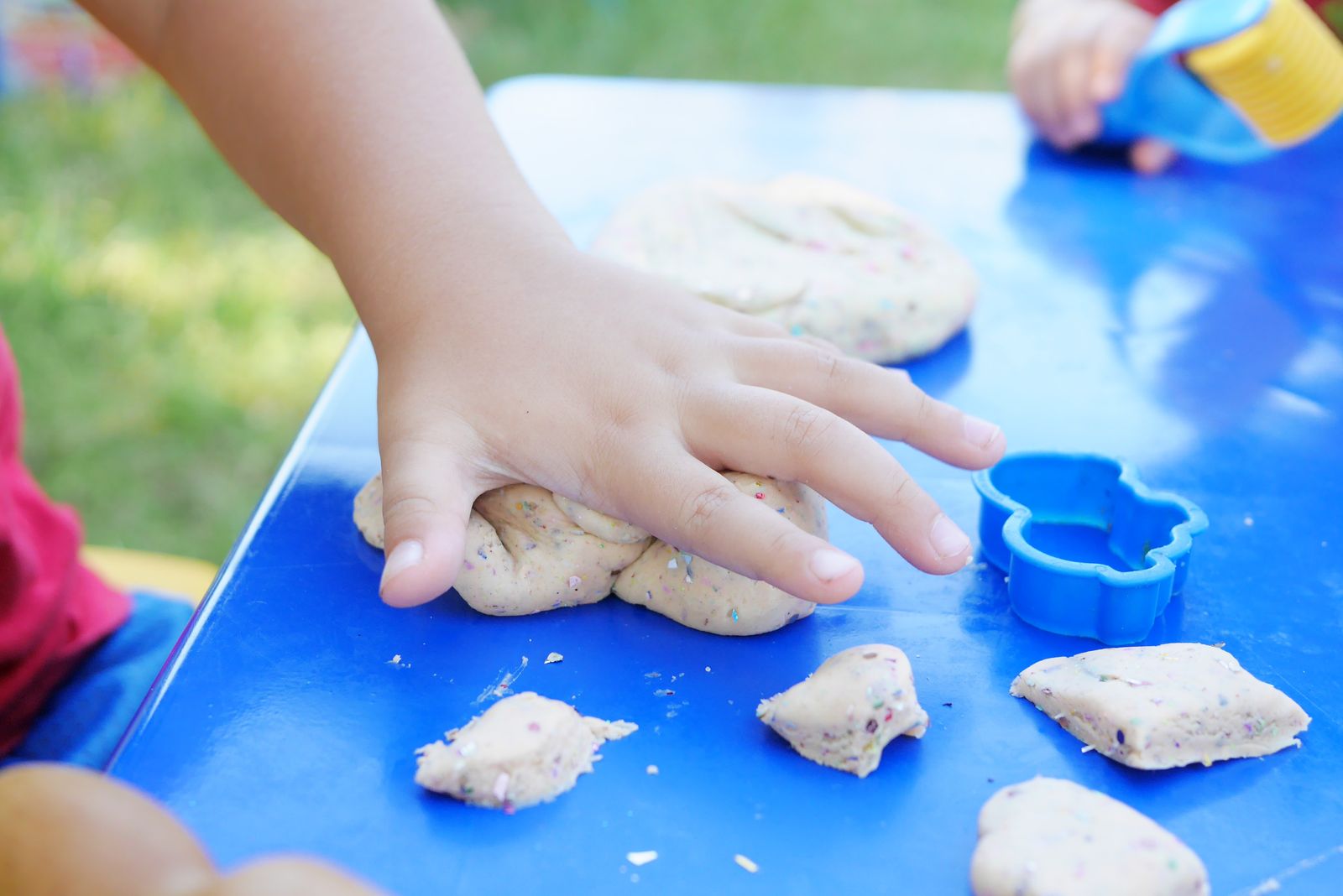 child rolling clay